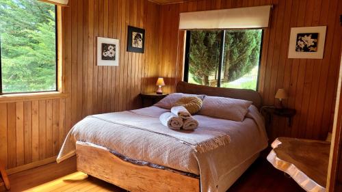 a bedroom with a bed with towels on it at Hostal Boutique El Vergel Azul in Castro
