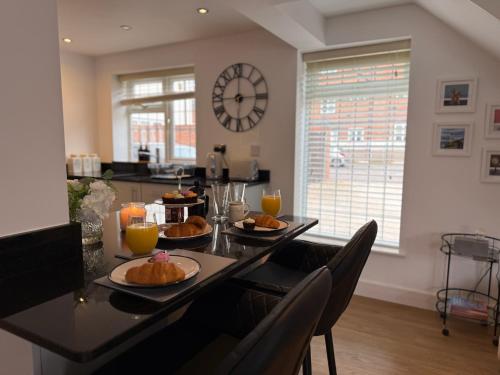 a table with plates of food on it with a clock at The Hayloft - A beautifully presented home in the heart of Leamington Spa in Leamington Spa