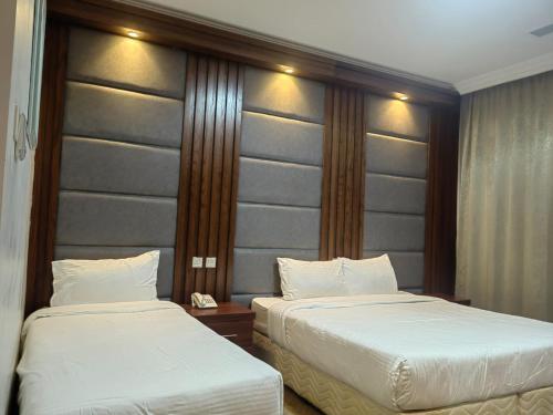 a hotel room with two beds and a headboard at Itlalat uhud hotel - فندق إطلالة احد in Al Madinah