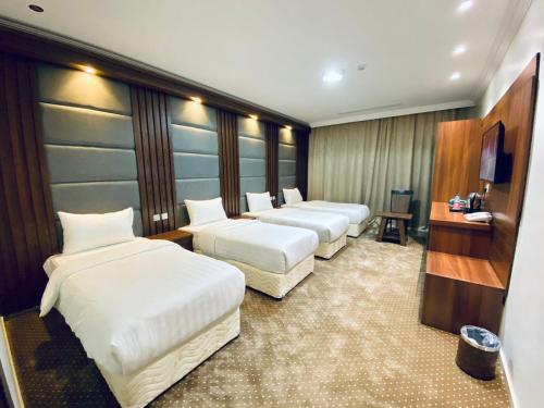 a row of beds in a hotel room at Itlalat uhud hotel - فندق إطلالة احد in Al Madinah
