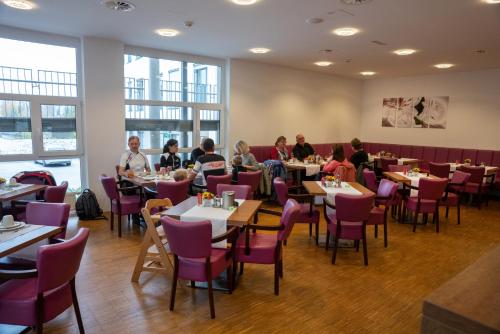 a group of people sitting at tables in a restaurant at Stadthotel Waidhofen an der Thaya in Waidhofen an der Thaya