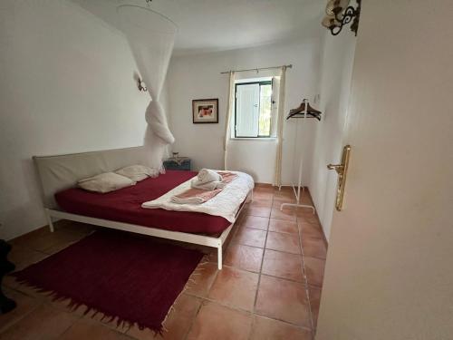 una camera da letto con un letto con una coperta rossa e una finestra di Casa Pereiro a Monte de Jangeis de Cima