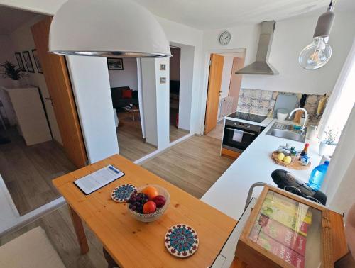 a kitchen and a table with a bowl of fruit on it at Penzión Tatroom in Poprad