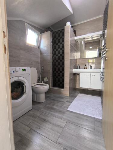 a bathroom with a washing machine and a toilet at Vila Đul in Konjic