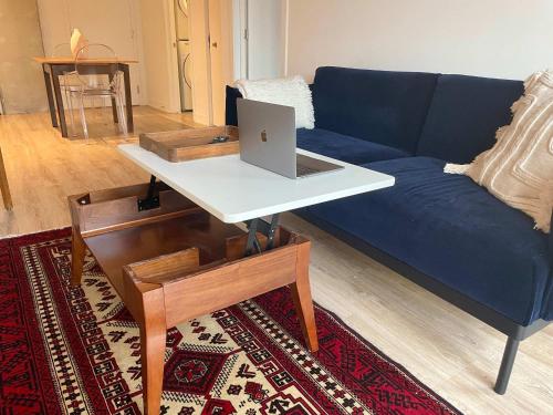 モントリオールにあるCozy apartment-Old Port Montrealのリビングルーム(ソファ、ノートパソコン、テーブル付)