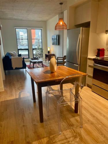 a kitchen and living room with a wooden table and chairs at Cozy apartment-Old Port Montreal in Montréal