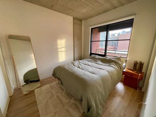 a bedroom with a bed and a large window at Cozy apartment-Old Port Montreal in Montréal