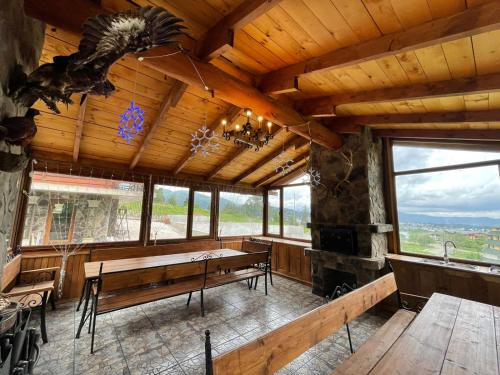 a dining room with a fireplace and wooden ceilings at Villa Fox Bakuriani in Bakuriani
