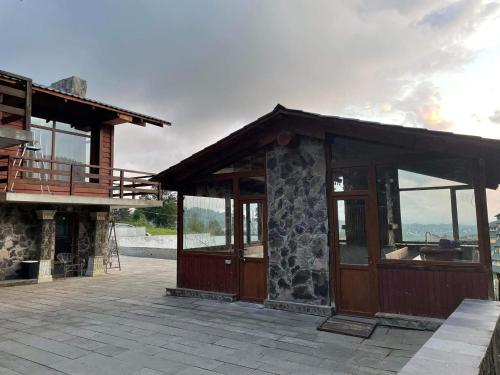 a building with a porch and a building with windows at Villa Fox Bakuriani in Bakuriani