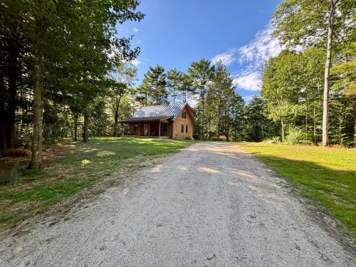 a dirt road leading to a house in the woods at Casco Cabin Freeport in Freeport