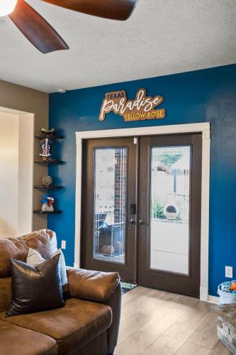 a living room with a leather couch in front of a restaurant at Tropical Escape Pool Jacuzzi Bar in Alvin TX in Alvin