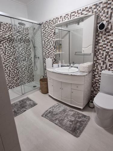 a bathroom with a toilet and a sink and a shower at Apartamento Brisa in Viana do Castelo