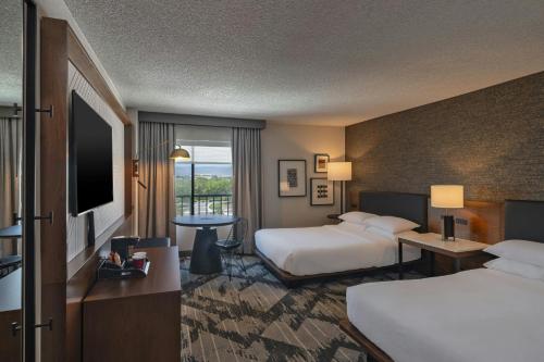 a hotel room with two beds and a television at Sheraton Albuquerque Airport Hotel in Albuquerque