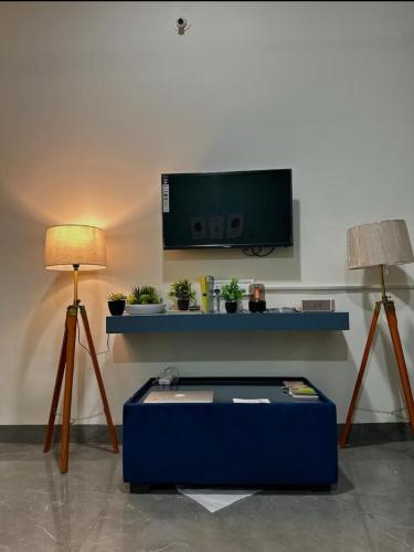 a living room with a tv and two lamps at Your Home in Indore