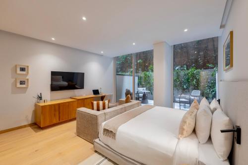 a bedroom with a large bed and a living room at Capitalia Juarez in Mexico City