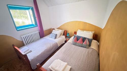 two twin beds in a room with a window at Blueberry Mountain House in Žabljak
