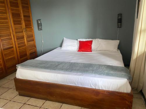 a bed with a red pillow on top of it at Hotel Manuel Antonio Inn in Quepos