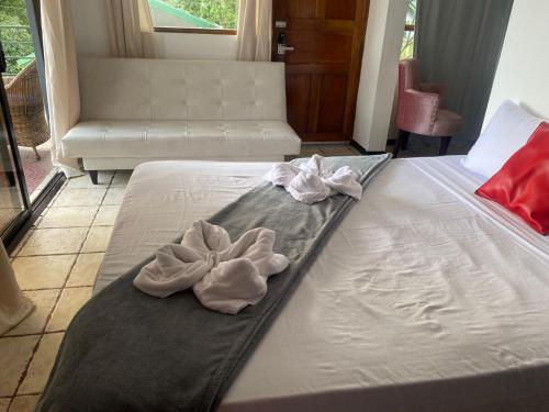 a white bed with two white towels on it at Hotel Manuel Antonio Inn in Quepos