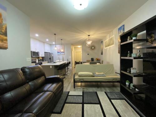 Una sala de estar con un sofá y una cocina. en Greensville Suites, en Regina