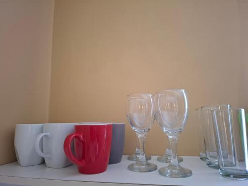 a table with wine glasses and cups on it at Sol de Paracas Apart Hotel Pisco in Pisco