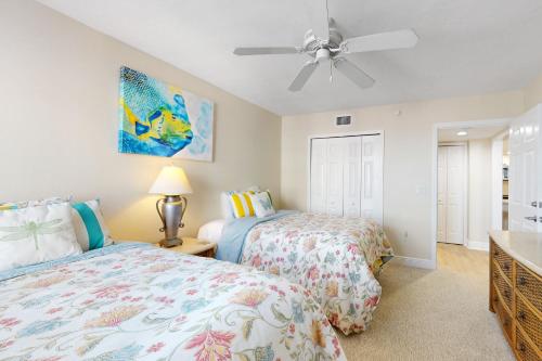 a bedroom with two beds and a ceiling fan at Gull Wing Views in Fort Myers Beach