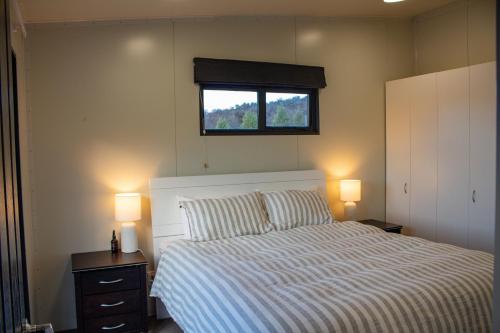 een slaapkamer met een bed met twee lampen en een raam bij Alpine Views Farm Stay in Lake Coleridge