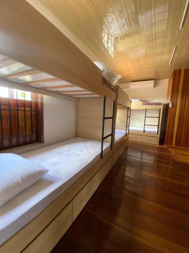 a bunk bed in a room with a wooden floor at Hostel Angatu Manaus in Manaus