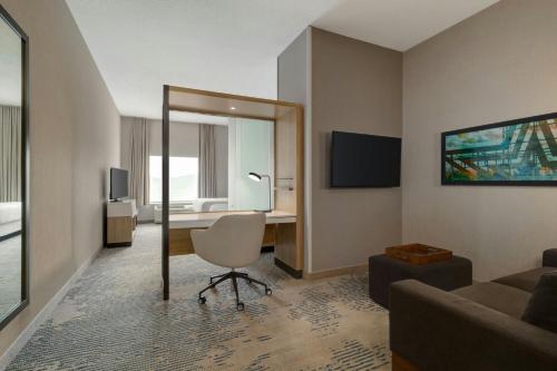 a living room with a chair and a mirror at SpringHill Suites by Marriott Roanoke in Roanoke