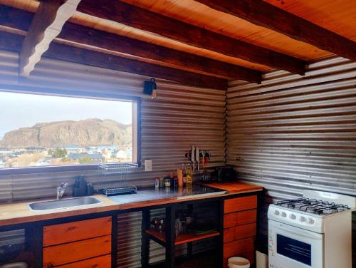 a kitchen with a stove and a sink and a window at Pizarra Escondida in El Chalten