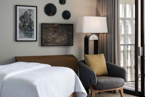 a bedroom with a bed and a chair and a lamp at Moana Surfrider, A Westin Resort & Spa, Waikiki Beach in Honolulu