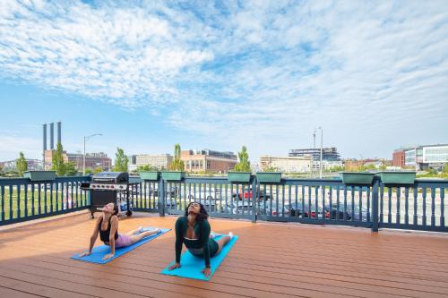 two women doing a yoga pose on a deck at The Hill in Providence