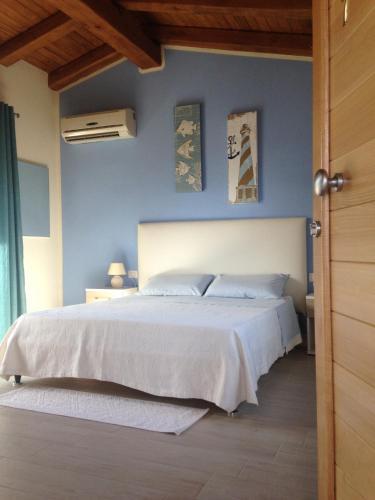 a bedroom with a large bed with blue walls at Mediterraneo in San Teodoro