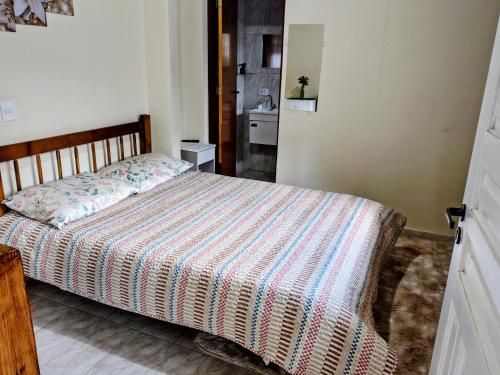 a bedroom with a bed with a striped comforter at Casa do Trem Suítes in Campos do Jordão