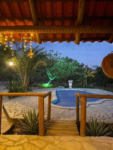 a view of a swimming pool at night with two benches at Cantinho da Herança in Pirenópolis