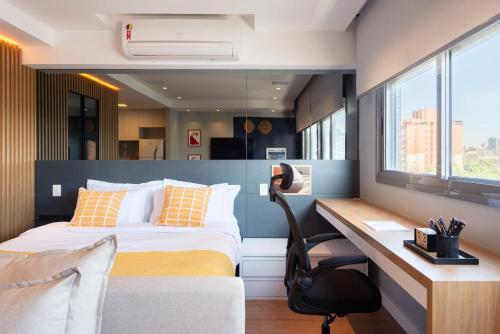 a hotel room with a bed and a desk and a desk at Hom Nilo Home by LikeHome in Porto Alegre