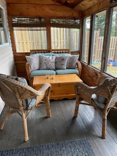 a porch with a couch and a table and chairs at Algonquin Waterfront and Winter Paradise With Sunsets in Algonquin Highlands