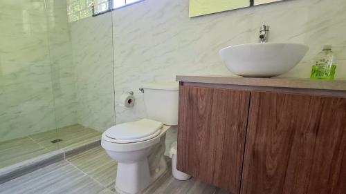 a bathroom with a toilet and a sink and a shower at Finca La Siria in Pereira