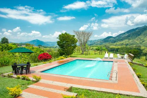 a swimming pool in a yard with a table and chairs at Finca La Siria in Pereira