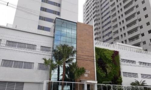 a building with palm trees in front of tall buildings at Refúgio Devant - COP 30 in Belém