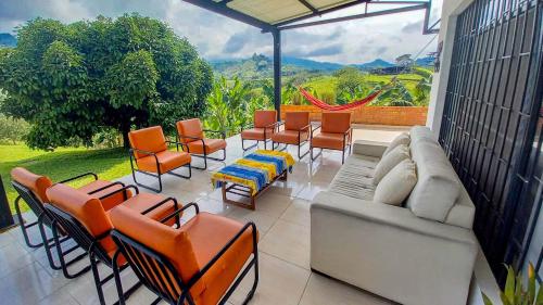 a patio with a couch and chairs and a view at Finca La Siria in Pereira