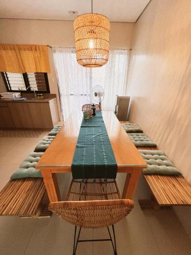 a dining room table with benches and a chandelier at Hooga Home in Cebu City