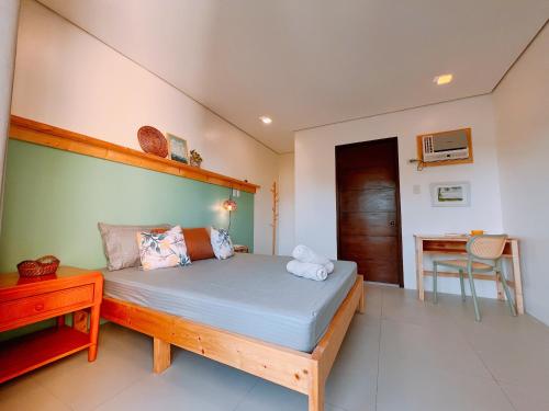 a bedroom with a large bed and a desk at Hooga Home in Cebu City