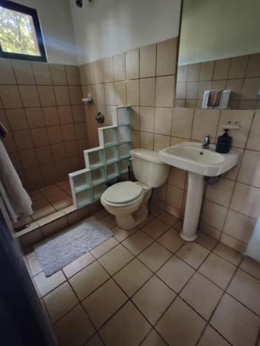 a bathroom with a toilet and a sink at Hotel Manuel Antonio Inn in Quepos