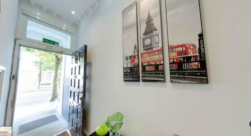 a hallway with two pictures of a train on the wall at Comfotel GRN in London