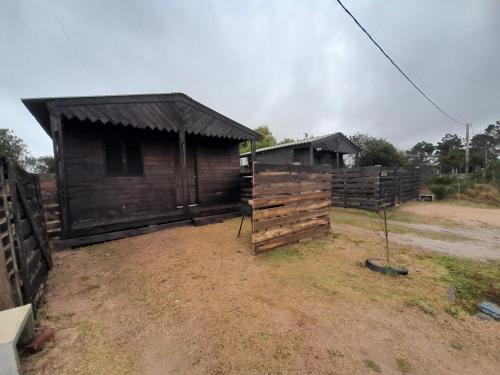 a small wooden building with a fence next to it at Cabañas CARPE DIEM Con o sin jacuzzi in Barra del Chuy