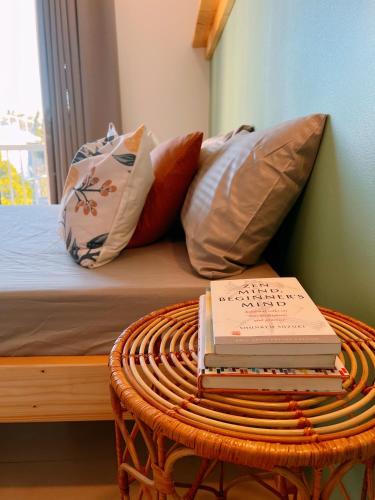 a stack of books sitting on a table next to a bed at Hooga Home in Cebu City