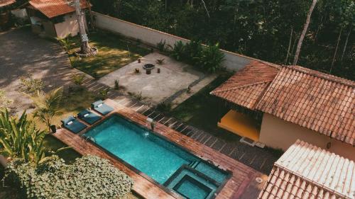 una vista aérea de una piscina junto a una casa en Chalé Refúgio da Mata em Trancoso, en Trancoso