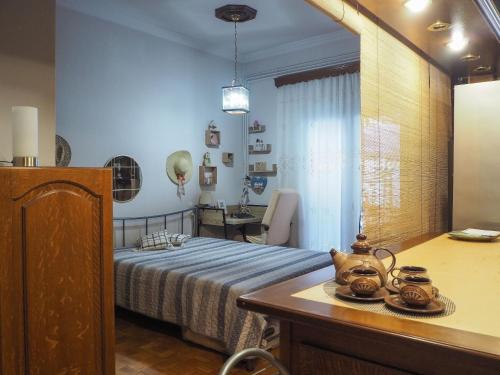 Un dormitorio con una cama y una mesa con un hervidor de agua. en Το σπίτι της Ολίβιας, en Volos