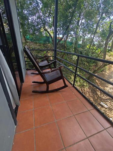 two chairs sitting on the porch of a house at Hotel Manuel Antonio Inn in Quepos