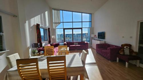 a living room with a table and chairs and a couch at Penthouse Ocean View Luxury Penthouse in Edinburgh